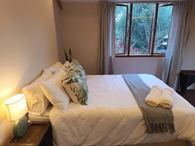 a bedroom with a bed with two towels on it at Koinonia Bush Lodge in Hartbeespoort