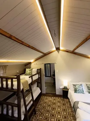 a room with two bunk beds and a living room at Koinonia Bush Lodge in Hartbeespoort