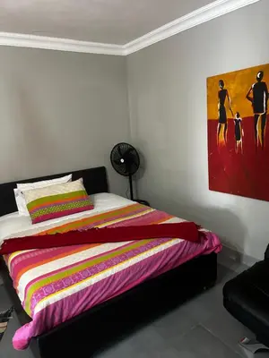 a bedroom with a bed with a painting on the wall at Garden Studio 2 Waterkloof Ridge in Pretoria