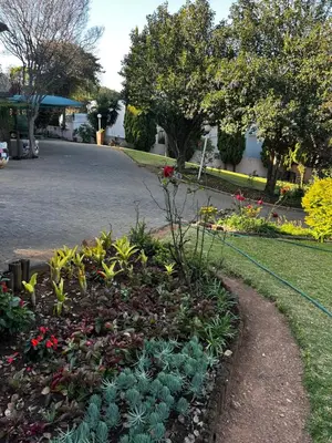 a garden with flowers and plants in a driveway at Garden Studio 2 Waterkloof Ridge in Pretoria
