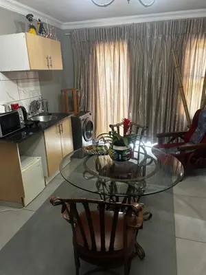a kitchen with a glass table and some chairs at Garden Studio 2 Waterkloof Ridge in Pretoria