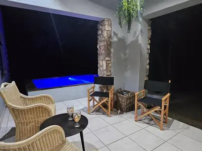 a living room with a large tv and tables and chairs at Kruger Amani Bush Retreat in Marloth Park