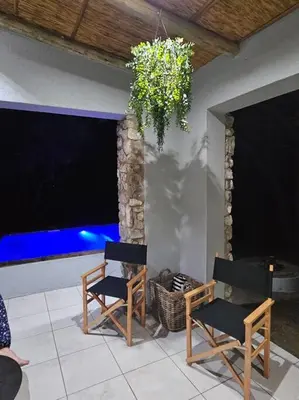 two chairs and a chandelier on a patio at Kruger Amani Bush Retreat in Marloth Park