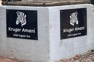 two signs on a wall with zebras on them at Kruger Amani Bush Retreat in Marloth Park