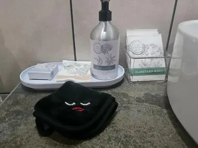 a black towel sitting on a counter next to a bottle of soap at Kruger Amani Bush Retreat in Marloth Park