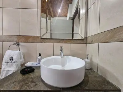 a bathroom with a white sink and a mirror at Kruger Amani Bush Retreat in Marloth Park
