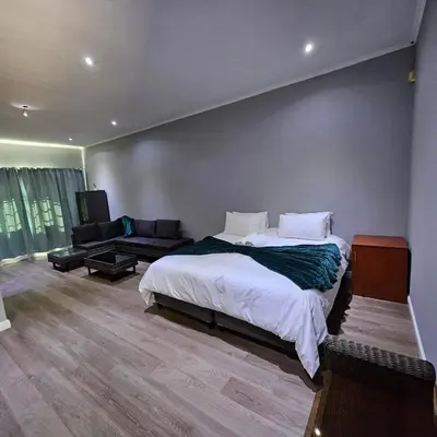 a bedroom with a large bed and a couch at Da Vinci Palms in Witbank