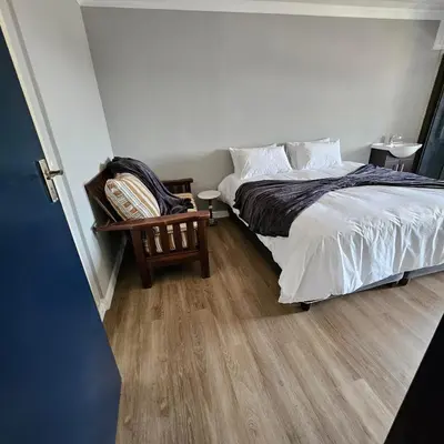 a bedroom with a bed and a wooden floor at Da Vinci Palms in Witbank