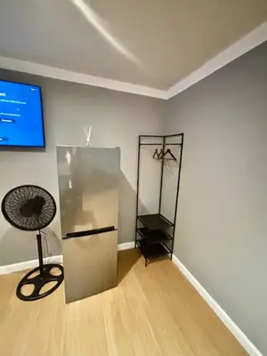 a room with a refrigerator and a tv on a wall at Da Vinci Palms in Witbank
