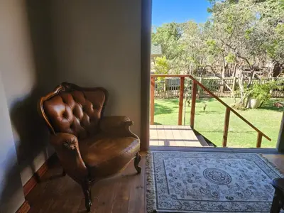 a leather chair in a room with a sliding glass door at Verloren Lodge in Modimolle