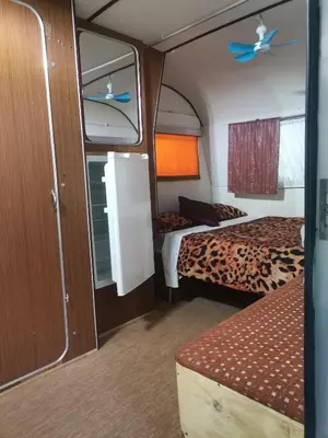 a small room with two beds and a ceiling fan at Hartbeespoort Cara-glamping self-cater units in Pretoria