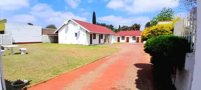 a house with red roofs and a dirt road at Royal Chestnut Guesthouse in Kempton Park