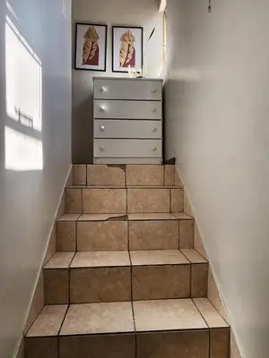 a staircase with a dresser and two pictures on the wall at Pearl palace in Polokwane