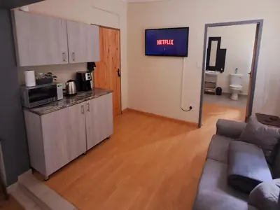 a living room with a couch and a kitchen at 26onMagazyn in Polokwane
