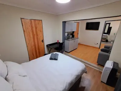a bedroom with a bed and a living room at 26onMagazyn in Polokwane