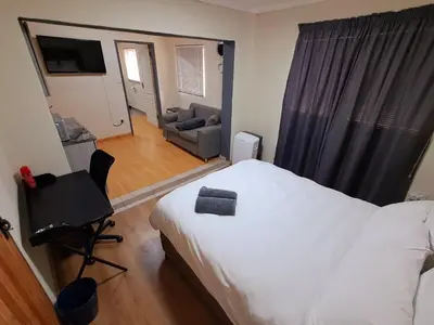 a bedroom with a bed and a chair and a couch at 26onMagazyn in Polokwane