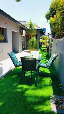 a patio with a table and chairs on the grass at The greenary guest house and restaurant in Thohoyandou