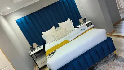 a large bed with a blue headboard in a room at The greenary guest house and restaurant in Thohoyandou