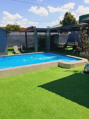 a swimming pool in a yard with green grass at The greenary guest house and restaurant in Thohoyandou