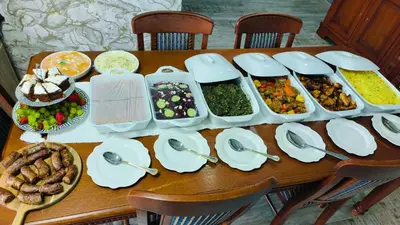 a wooden table with plates and bowls of food at The greenary guest house and restaurant in Thohoyandou