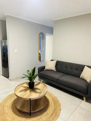 a living room with a couch and a coffee table at Homely Stay in Kempton Park