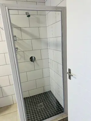 a shower with a glass door in a bathroom at Homely Stay in Kempton Park