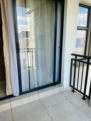 a balcony with a window with white curtains at Homely Stay in Kempton Park