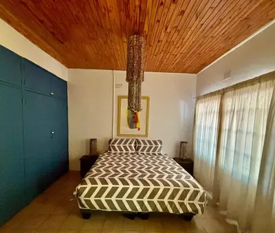 a bedroom with a bed with a wooden ceiling at The Seed Pod Guesthouse in Haningfontein