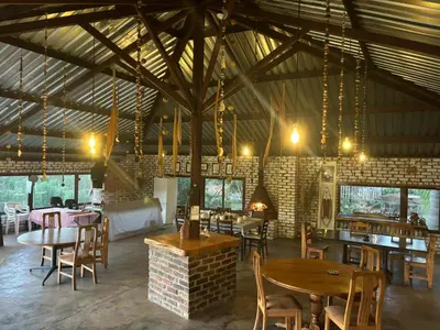 a restaurant with tables and chairs in a building at The Seed Pod Guesthouse in Haningfontein