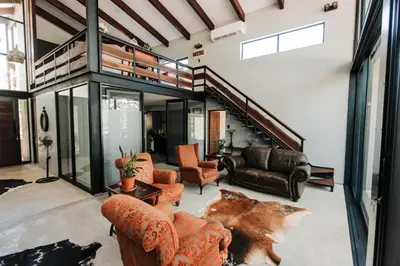 a living room filled with furniture and a staircase at Idyllic Kruger Breeze Marloth Park - 4 Bedroom in Marloth Park
