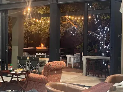 a patio with chairs and tables and lights at Idyllic Kruger Breeze Marloth Park - 4 Bedroom in Marloth Park