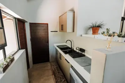 a small kitchen with a sink and a refrigerator at Idyllic Kruger Breeze Marloth Park - 4 Bedroom in Marloth Park