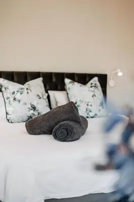 two towels are sitting on a bed with pillows at Idyllic Kruger Breeze Marloth Park - 4 Bedroom in Marloth Park