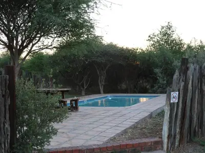 a swimming pool in a yard with a wooden fence at Ngata Safari Lodge in Hammanskraal