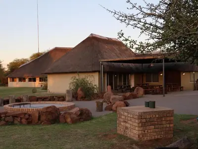 a building with a fire pit in the yard at Ngata Safari Lodge in Hammanskraal