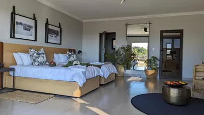 a bedroom with two beds with white sheets at Umlingo Lodge in Melkrivier