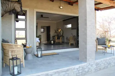 a living room with a large glass door on a patio at Umlingo Lodge in Melkrivier