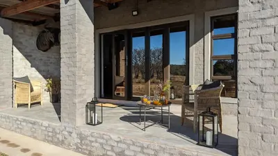 a patio of a house with a table and chairs at Umlingo Lodge in Melkrivier