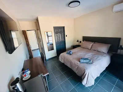 a bedroom with a bed and a table and a mirror at Chill Out in Malelane