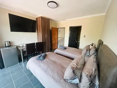 a hotel room with two beds and a television at Chill Out in Malelane