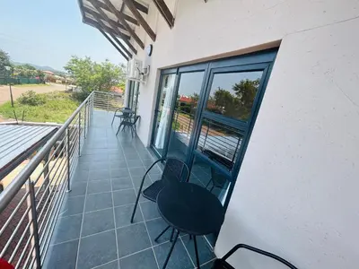 a balcony with chairs and tables on a building at Chill Out in Malelane