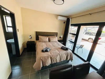 a bedroom with a bed and a balcony at Chill Out in Malelane