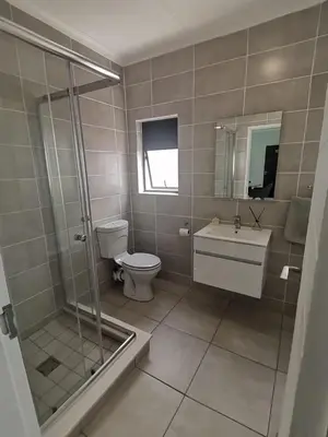 a bathroom with a shower and a toilet and a sink at The Blyde Crystal Lagoon - 3 Bedrooms with Lagoon Views in Pretoria