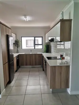a kitchen with wooden cabinets and a counter top at The Blyde Crystal Lagoon - 3 Bedrooms with Lagoon Views in Pretoria