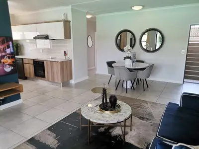 a living room with a kitchen and a table in a room at The Blyde Crystal Lagoon - 3 Bedrooms with Lagoon Views in Pretoria