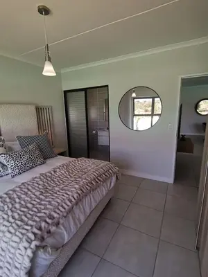 a bedroom with a large bed and a mirror at The Blyde Crystal Lagoon - 3 Bedrooms with Lagoon Views in Pretoria