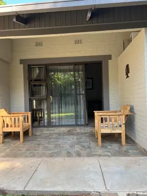 two wooden benches sitting outside of a house at Toshari BnB in Musina