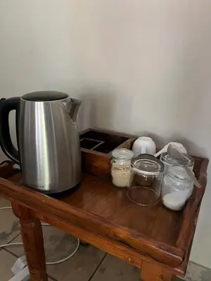 a coffee pot and jars on a wooden table at Toshari BnB in Musina