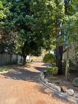 a walk way with trees and rocks on a street at Toshari BnB in Musina