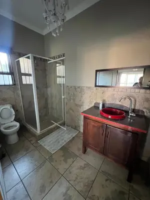 a bathroom with a shower and a sink and a toilet at Toshari BnB in Musina